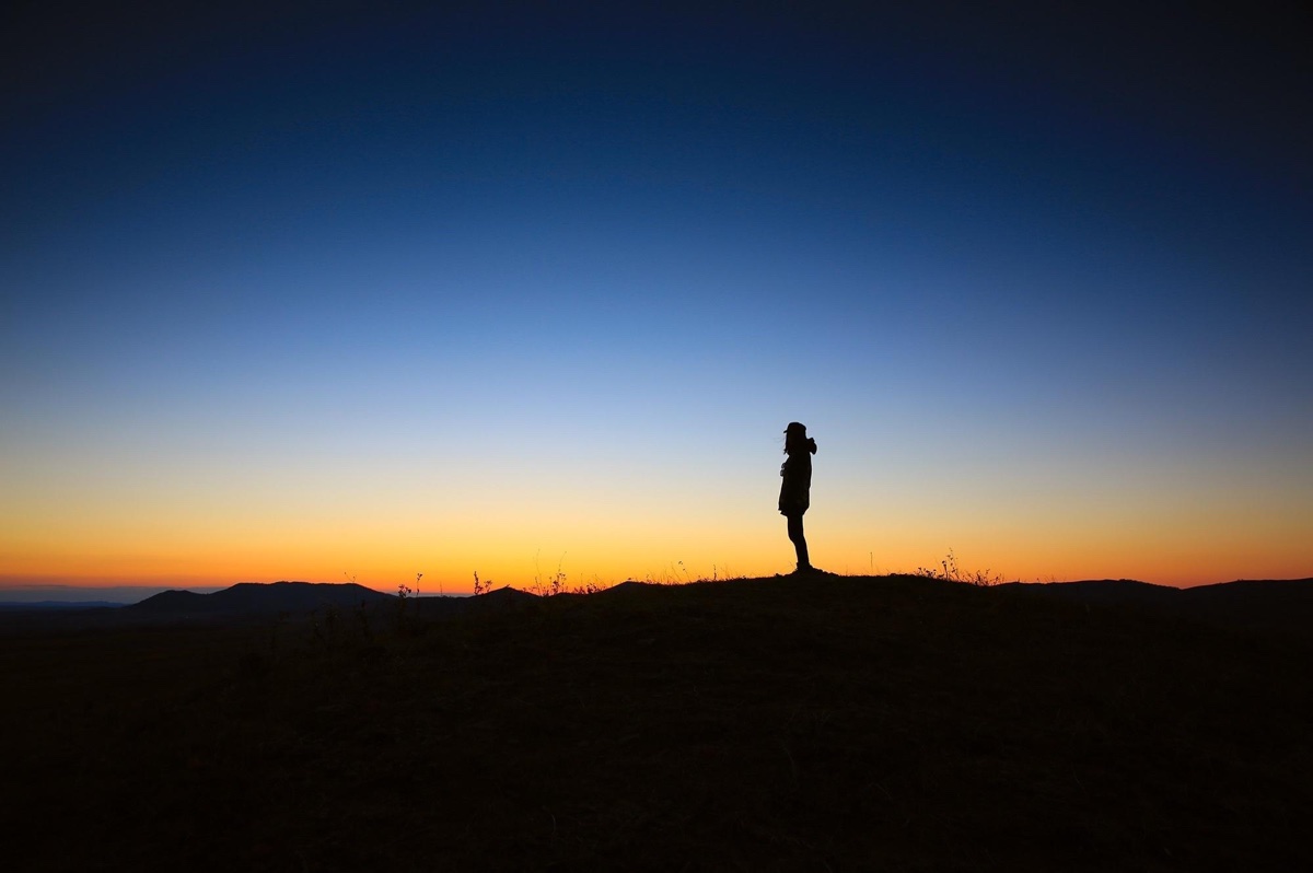 Lone Person Standing In Sunset Looking Away