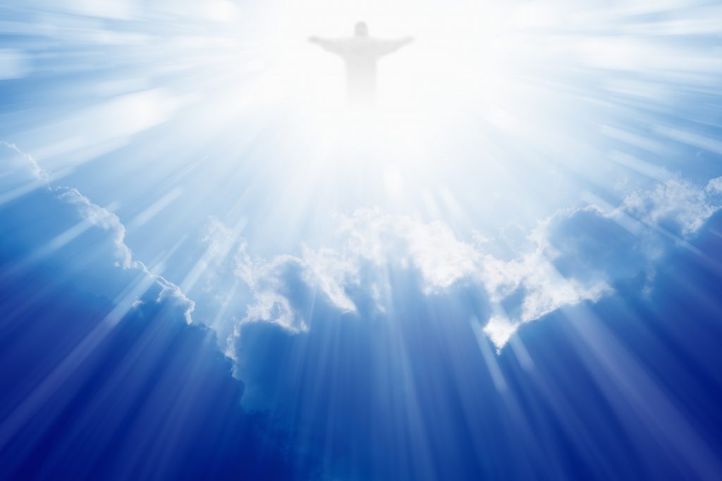 Jesus in blue sky, hands stretched out, in glorious light