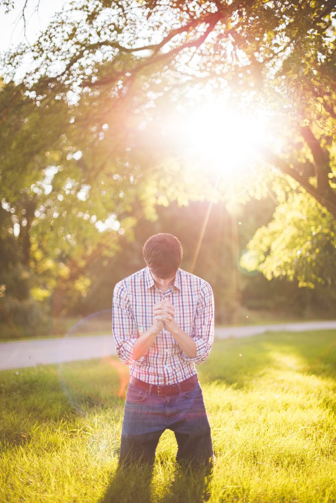 man praying in the sun