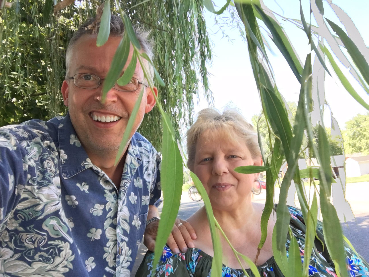 Christian and Helen Bohlen peeking through the Weeping Willow jungle on their walk to the grocery store