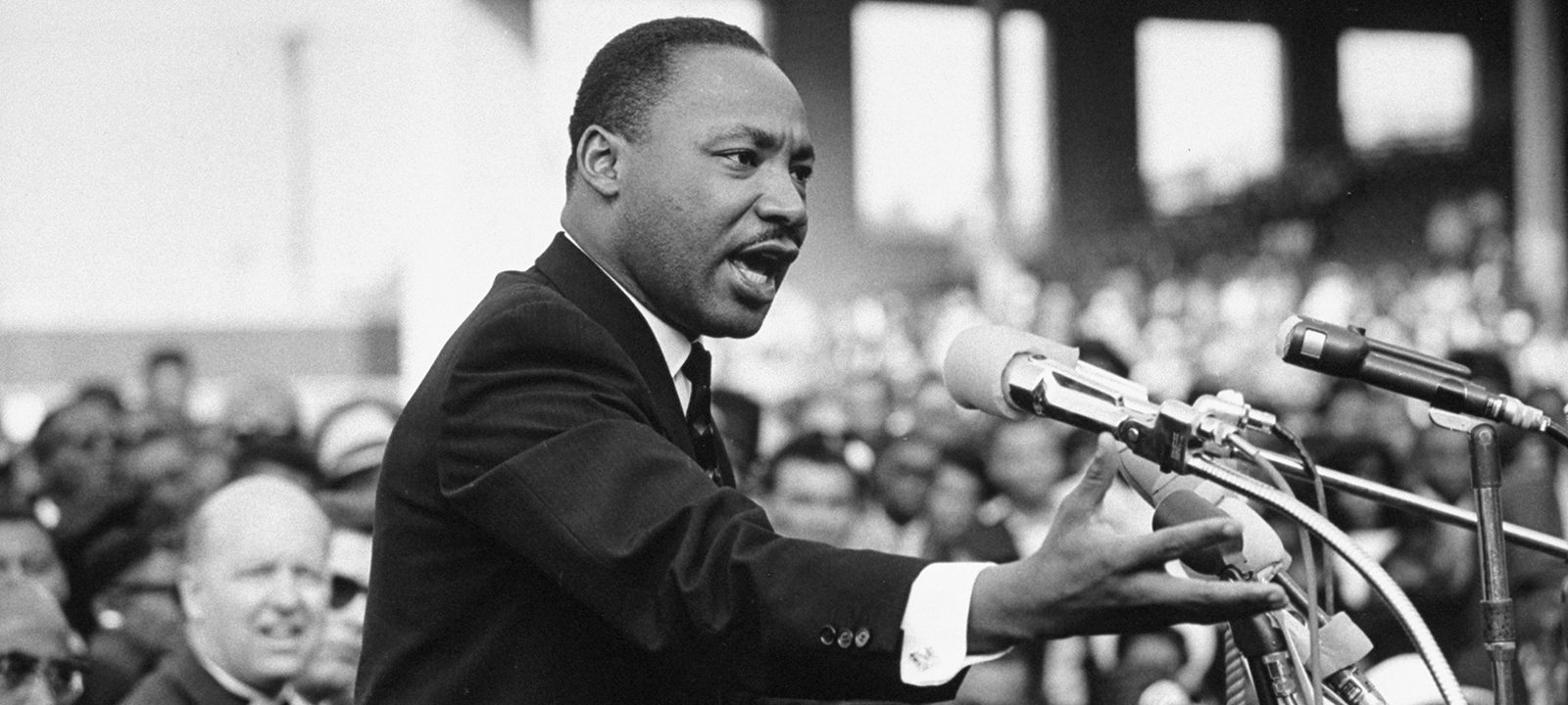 Martin luther king speaking passionately in large gathering