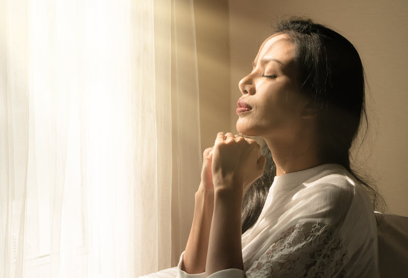 Woman praying in light